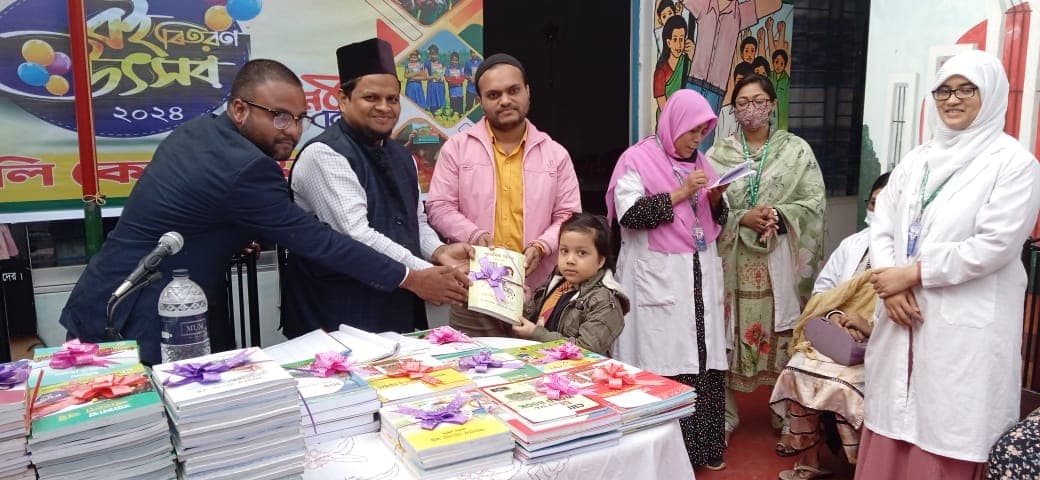 A young student receiving books at Holy Care School