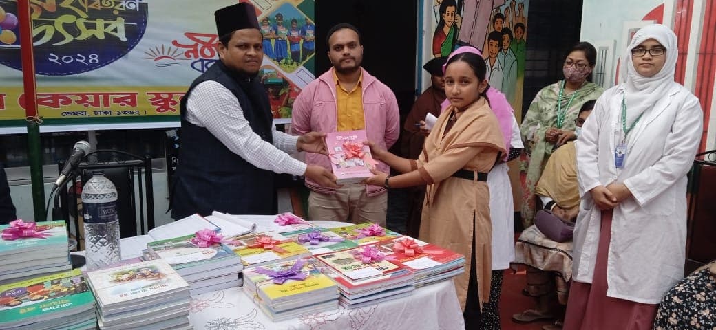 A student receiving a bundle of books from school representatives
